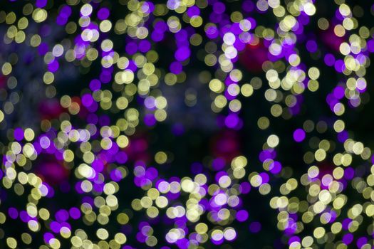 Defocused of glitter or yellow and purple bokeh circle at night as background.