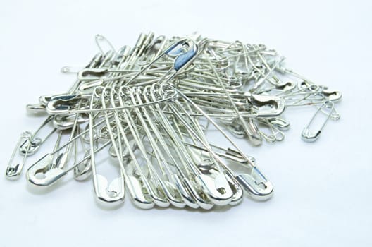 Stack of safety pins on white background
