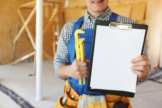 Workman with adjustable wrench and folder with blank document