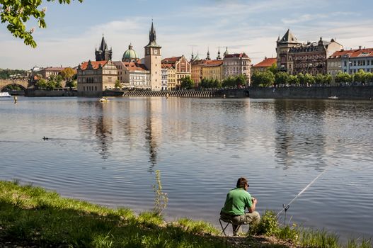 Vtlava River view with a fisherman in Prague, Czech Republic