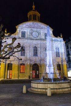 Geneva, Switzerland - December 13, 2014: The Fusterie fountain and temple at night, illuminated with Christmas decorations, in downtown Geneva.