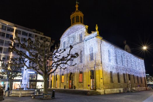 Geneva, Switzerland - December 13, 2014: The Fusterie temple at night, illuminated with Christmas decorations, in downtown Geneva.