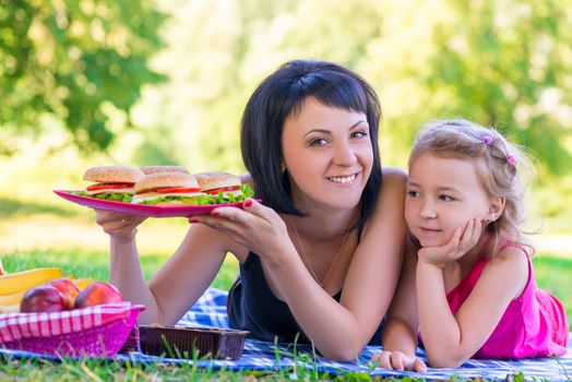 young beautiful mother holding a plate with burgers