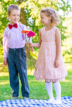 little couple in love on a meadow with a bouquet of flowers