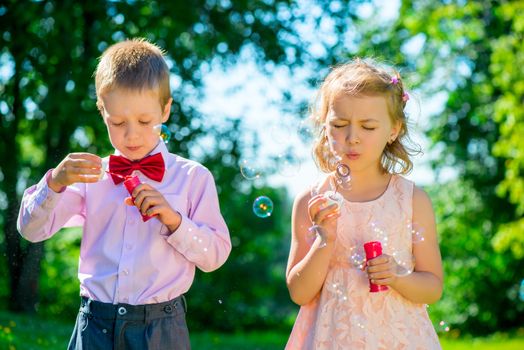happy children doing soap bubbles outdoors