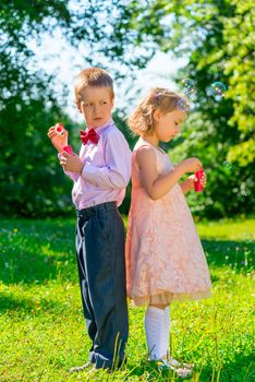 funny kids on a holiday makes soap bubbles