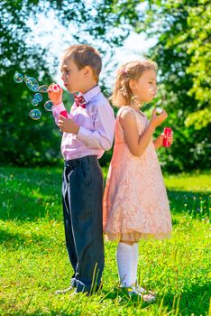 preschool age children with soap bubbles outdoors