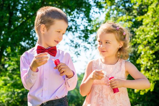 Happy laughing children doing soap bubbles