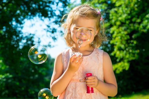 beautiful girl with soap bubbles in the park