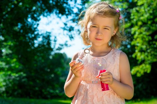 girl holding soap bubbles in the park