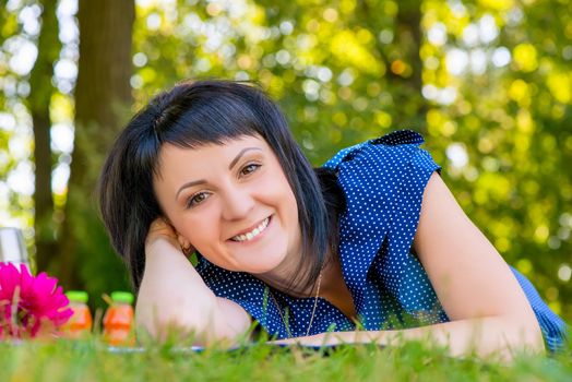 cheerful young woman resting lying on a picnic