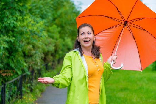 bright girl with an umbrella on a rainy day on the walk