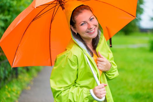 brunette laughing under an orange umbrella closeup