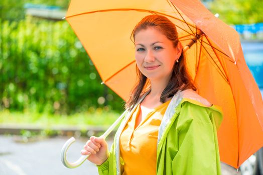 portrait of a beautiful girl with an orange umbrella closeup