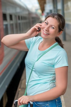 portrait of a beautiful smiling girl with a phone at the station