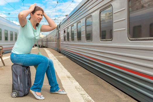 frustrated woman looking at the passing train on which she was late