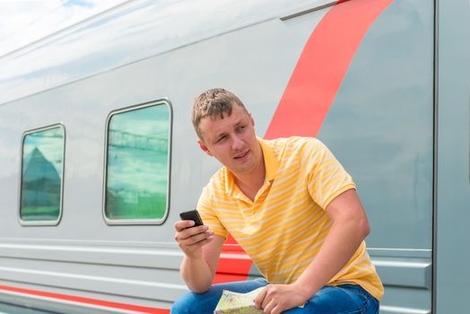 portrait of a man with the phone near long-distance trains