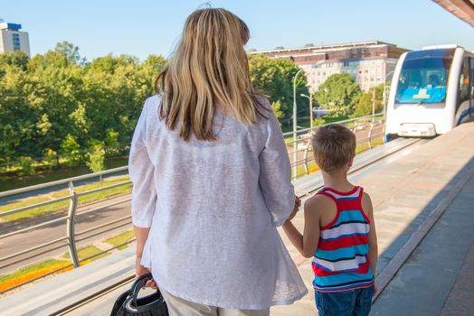 a woman with a child on the platform waiting for the train