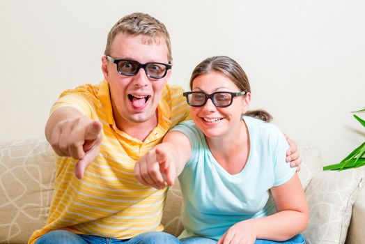 happy couple in 3D glasses watching television at home