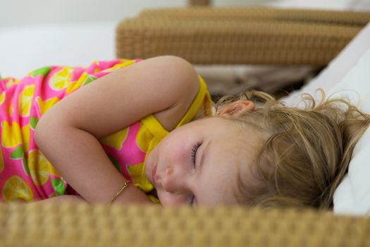 Young blond girl napping on a sun lounger