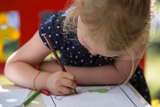 Young blond girl coloring a page