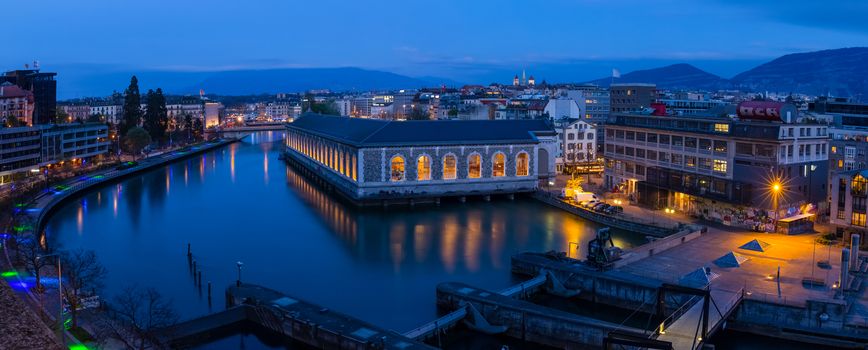 Panoramic of Geneva at the blue hour. The Seujet dam, the Rhone river and the city