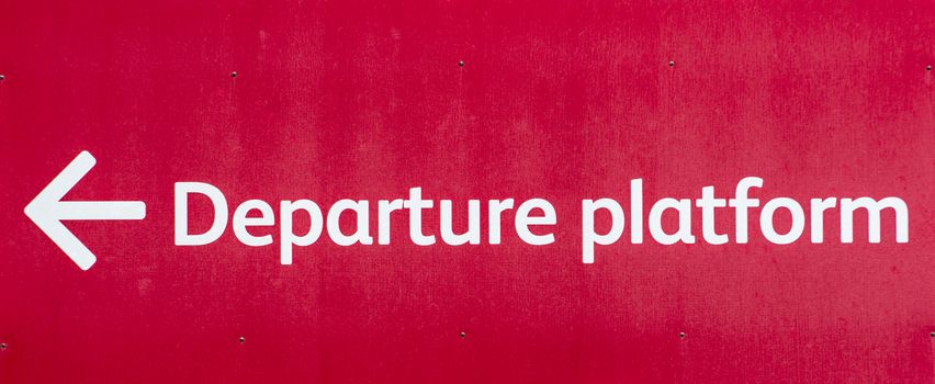 Vivid red sign pointing towards the Departure Platform