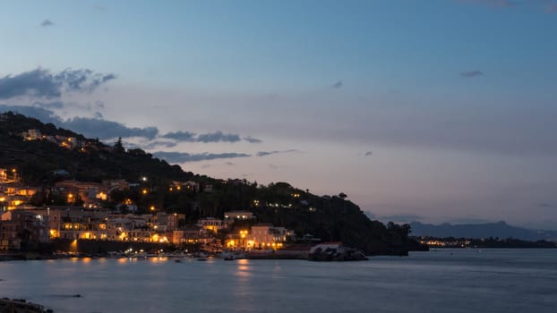 Waterfront street and old buildings by night.