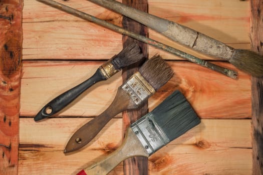 Used paintbrushes on a old wooden table.