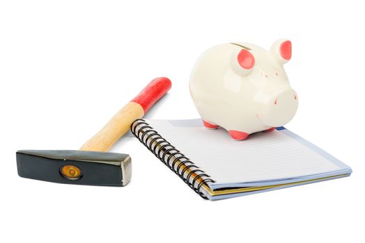 Piggy bank with hammer and pad on isolated white background