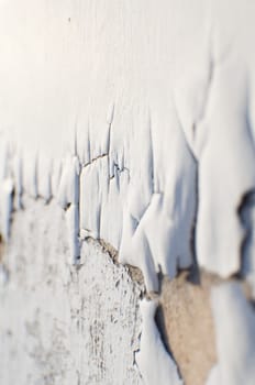 Whit paint cracking on the side of an abandoned building