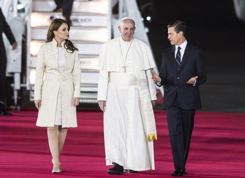 MEXICO, Mexico City: Mexican President Enrique Pena Nieto (R) next to First Lady Angelica Rivera welcoming Pope Francis (C) upon his arrival at Benito Juarez international airport in Mexico City on February 12, 2016. Catholic faithful flocked to the streets of Mexico City to greet Pope Francis on Friday after the pontiff held a historic meeting with the head of the Russian Orthodox Church in Cuba.