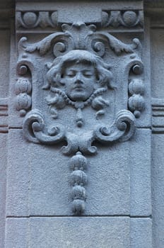 Woman face on the wall. Architecture detail. Stone sculpture. Parged with plaster
