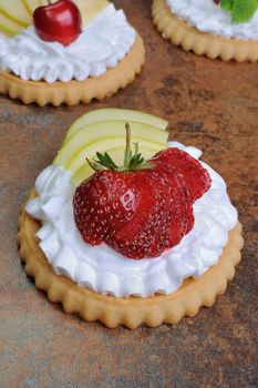 Tartlets filled   whipped cream and apples with raspberries