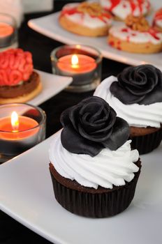 Chocolate muffin with cream decorated with black protein rose from marzipan