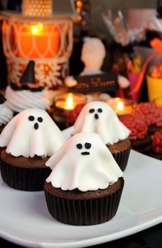 Chocolate muffin garnished ghost of marzipan among sweets  Halloween