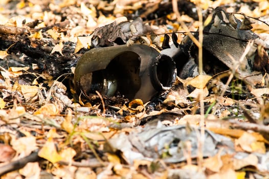 burned trash in the woods among the leaves