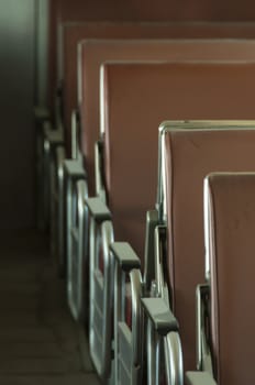 Six Brown Seats lines up within an unoccupied train