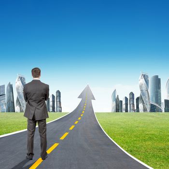 Businessman standing on highway road going up as an arrow in sky