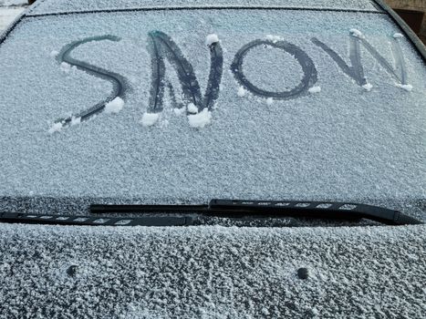The words snow written on the windshielf through the snow
