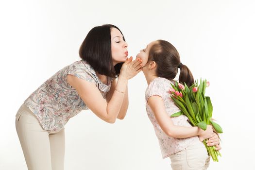 the girl hides a bouquet of flowers for mother behind the back