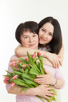 the woman presented a bouquet of flowers for mother and embraces her