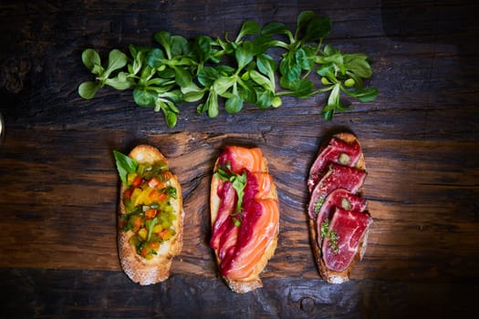 Various bruschettas on wooden table, top view