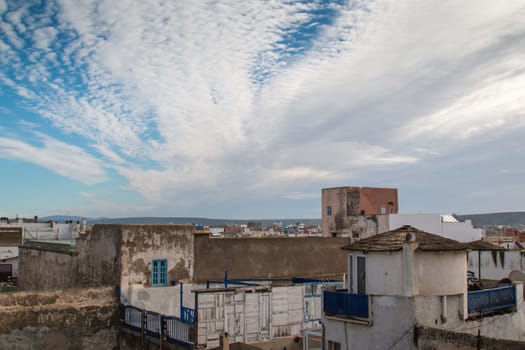 View from a roof of a house on the city Essaouira. Intense clouds. Mountains in the background.