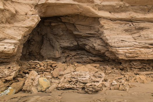 Sandy color of the stones and rocks with a cave. Atlantic coast in Morocco.