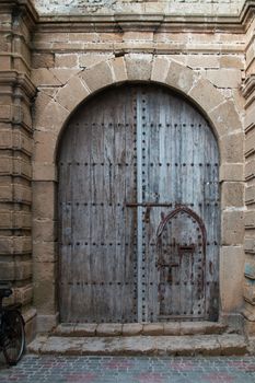 Blue old wooden gate in the building made of stones.