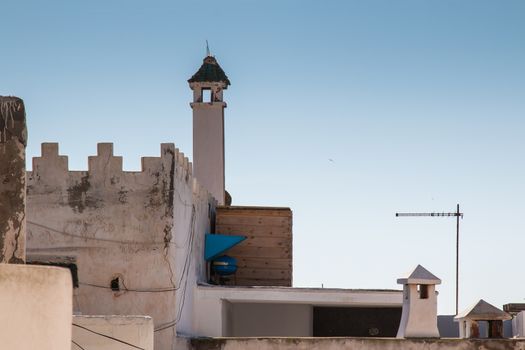 View on the roofs and chimneys of the houses in Essouira, Morocco. Early morning light blue sky.