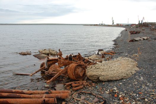 Old rusty abandoned metal vehicle parts at arctic sea coast, Pevek town, Chukotka, Russia