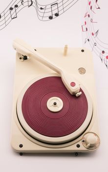 composition with vintage red record player and musical notes on background