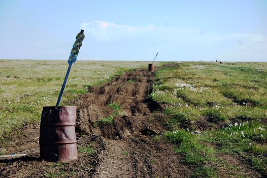 Old oil drum with road mark stake at tundra, Ayon Island, Chukotka, Russia